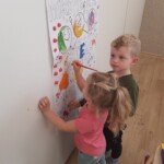 Dziewczynka i chłopiec malują plakat