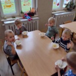 Dzieci siedzą przy stole z miseczkami