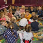 Dzieci siedzą na dywanie