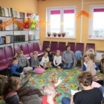 Dzieci siedzą na dywanie