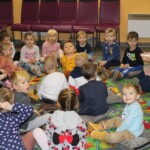 Dzieci siedzą na dywanie