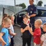 Chłopcy trzymają "lizak" policyjny