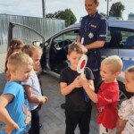 Chłopcy trzymają "lizak" policyjny
