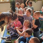 Głaskanie przez dzieci dinozaura